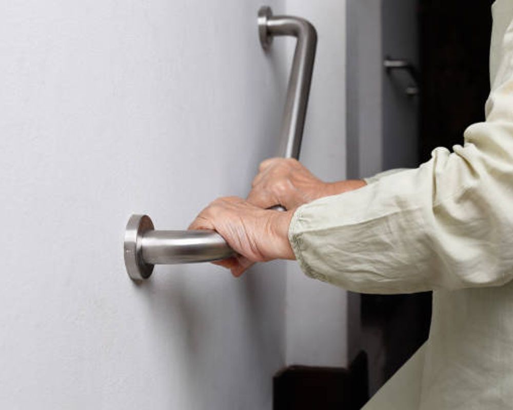 A hand holding a bathroom grab rail